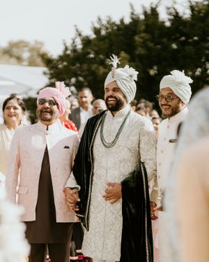 Group wearing traditional Indian wedding attire at outdoor celebration.