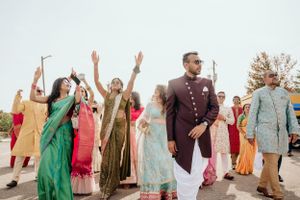 Wedding celebration with guests in colorful traditional attire dancing outdoors.