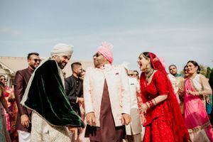 Traditional Indian wedding ceremony guests interact joyfully during outdoor celebrations.