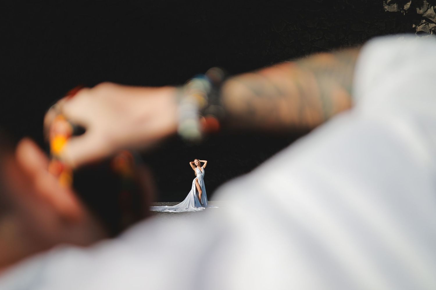 Miniature figure standing on white surface with tattooed arm in background.