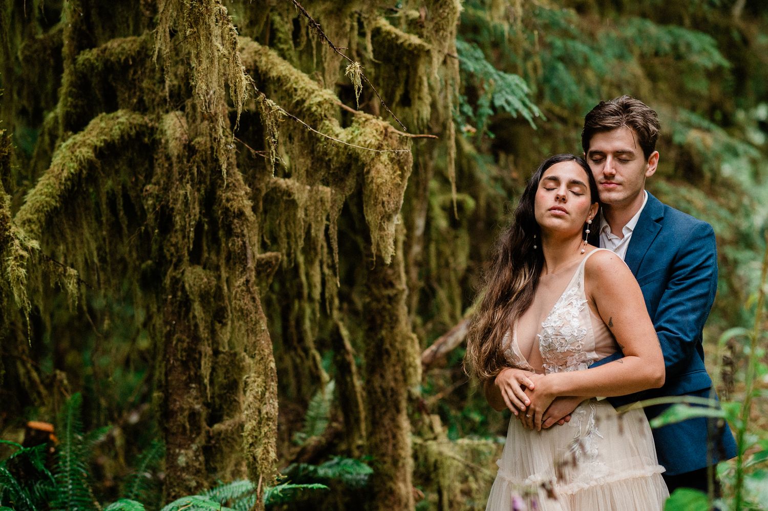 couple snuggling under moss and ferns in Olympic National Park
