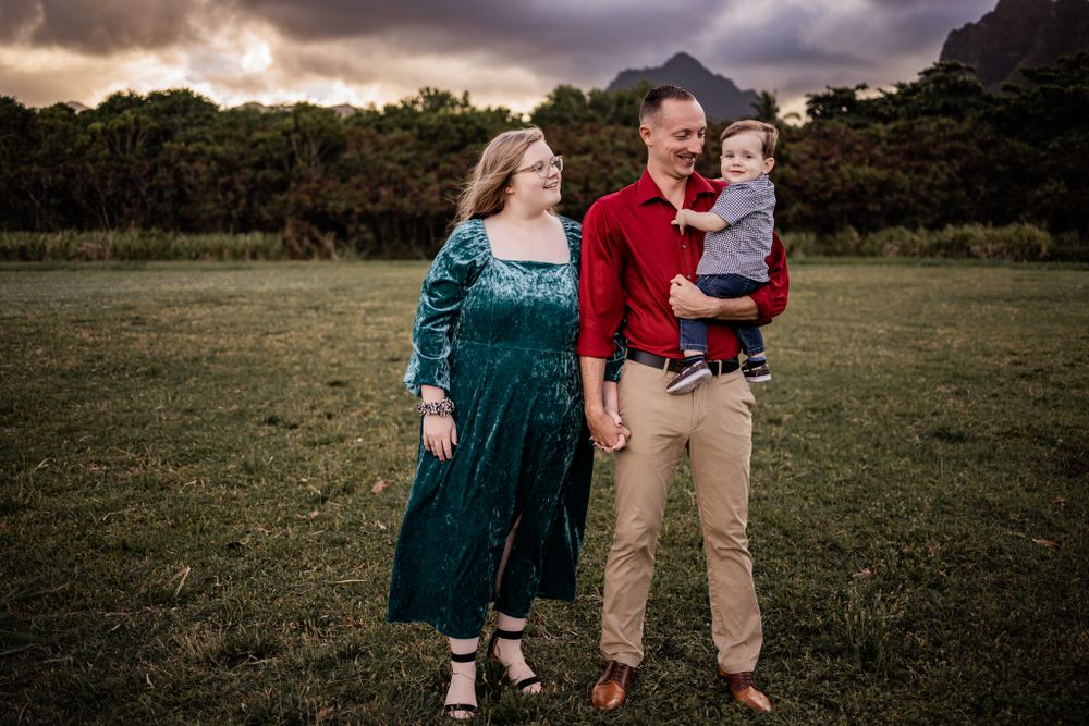 A family enjoys a heartwarming moment together in an outdoor setting with mountains in the background.