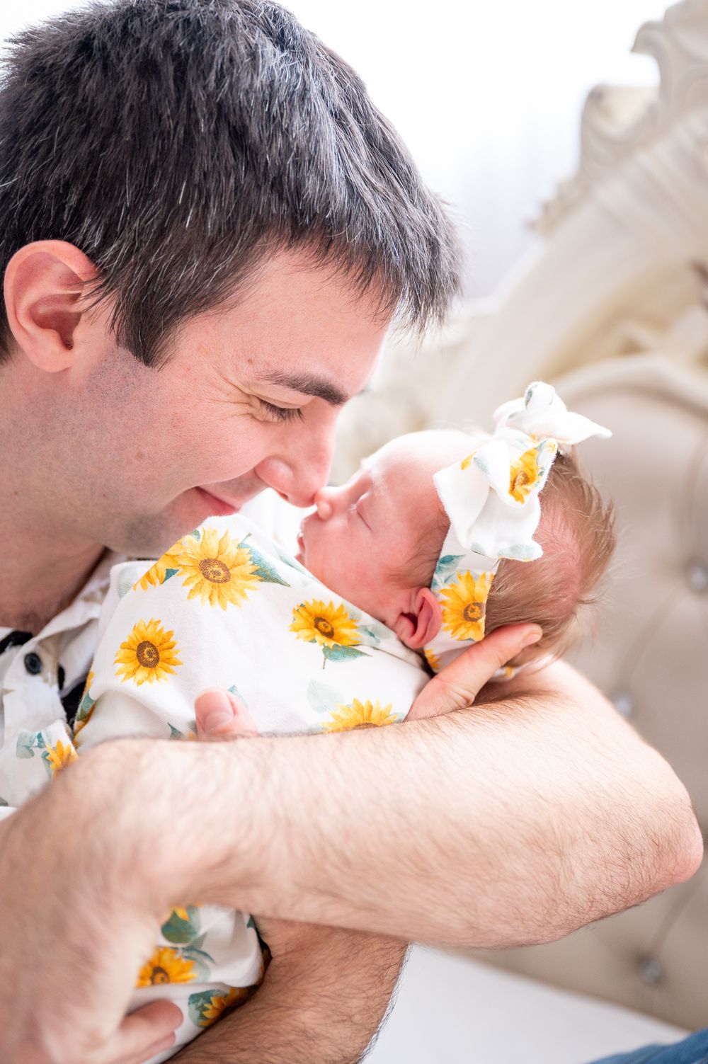 Newborn receiving nose kisses from her Dad