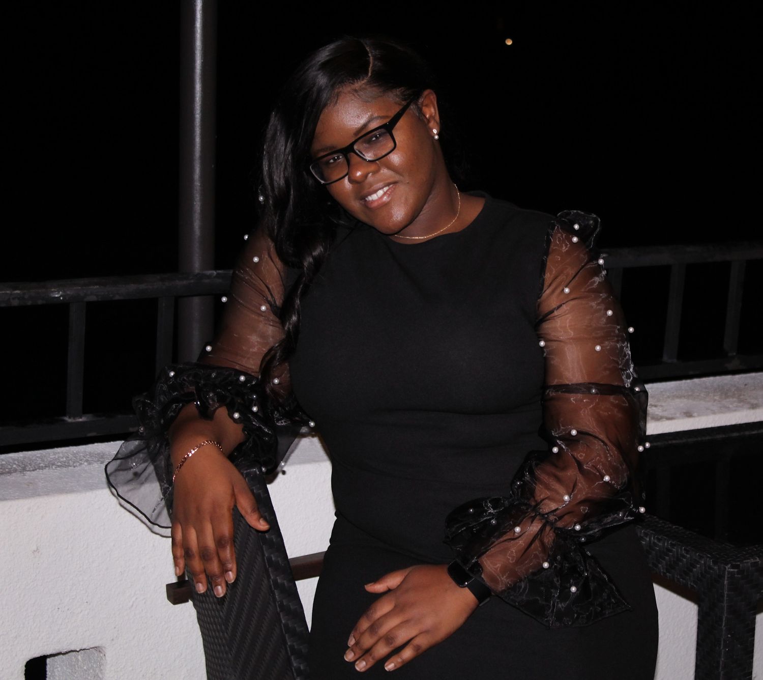 A stylish evening portrait featuring a black dress with sparkly sheer sleeves.