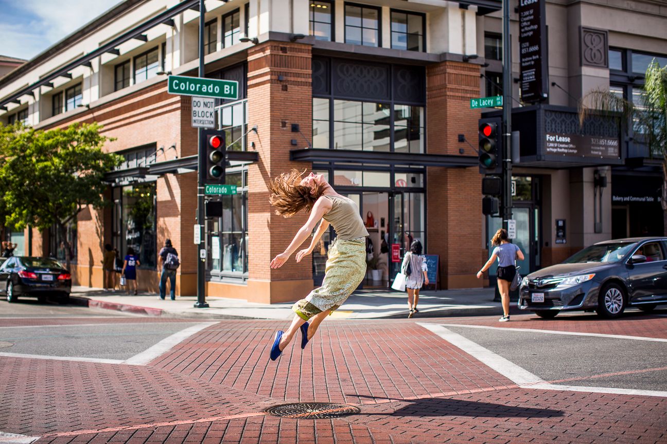 Urban street corner with brick buildings and pedestrian crosswalk.