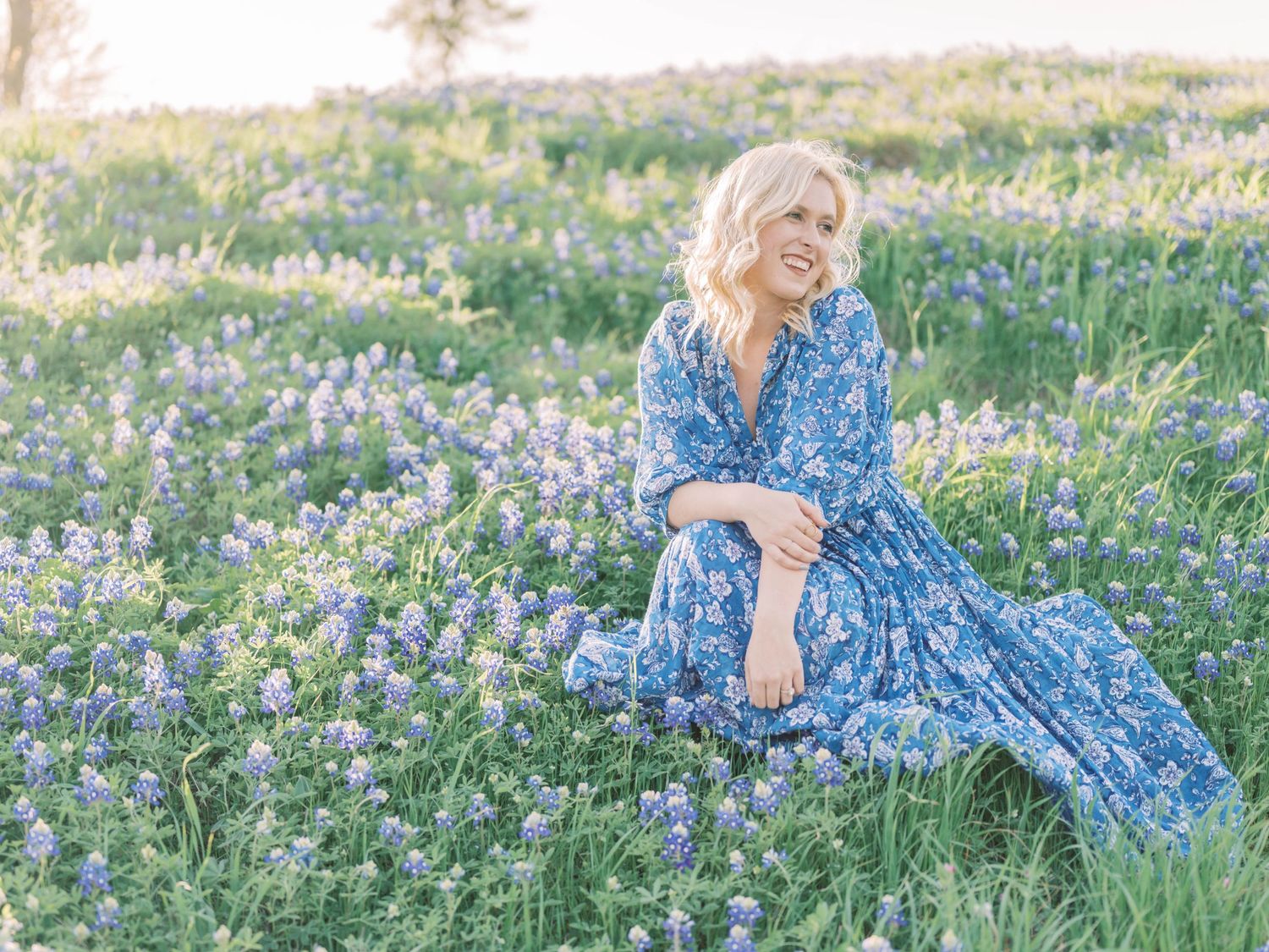 girl smiling in a field of bluebonnets