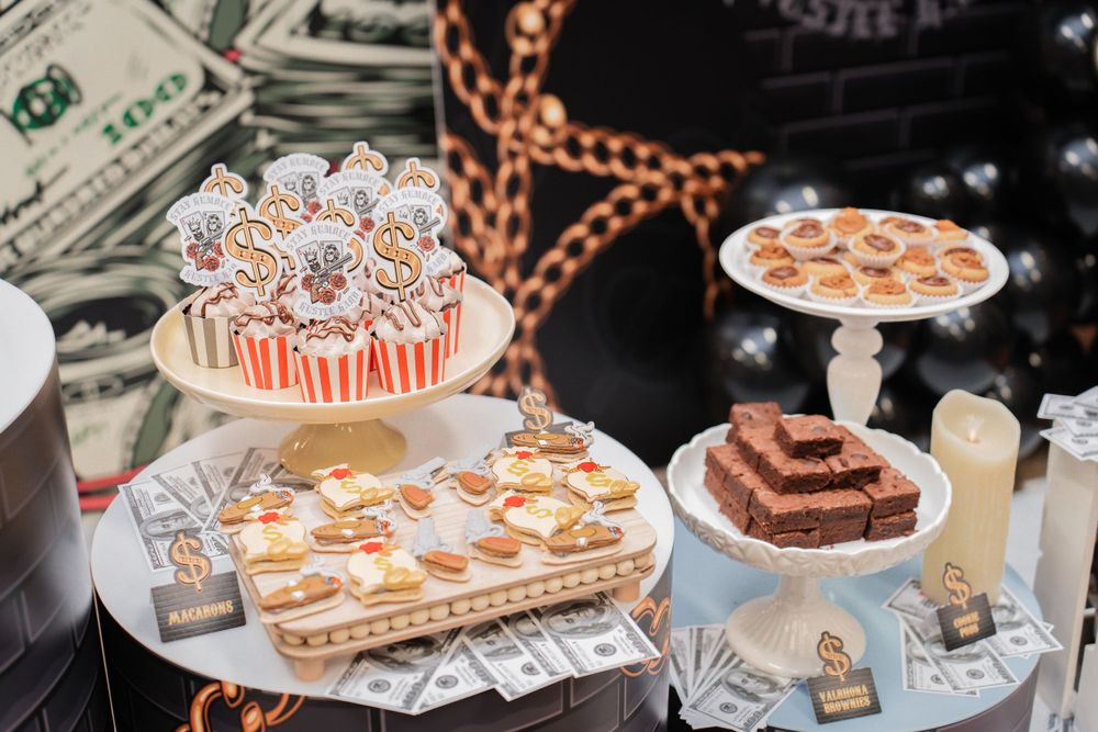 Elegant dessert table with money-themed treats and decorations on display.