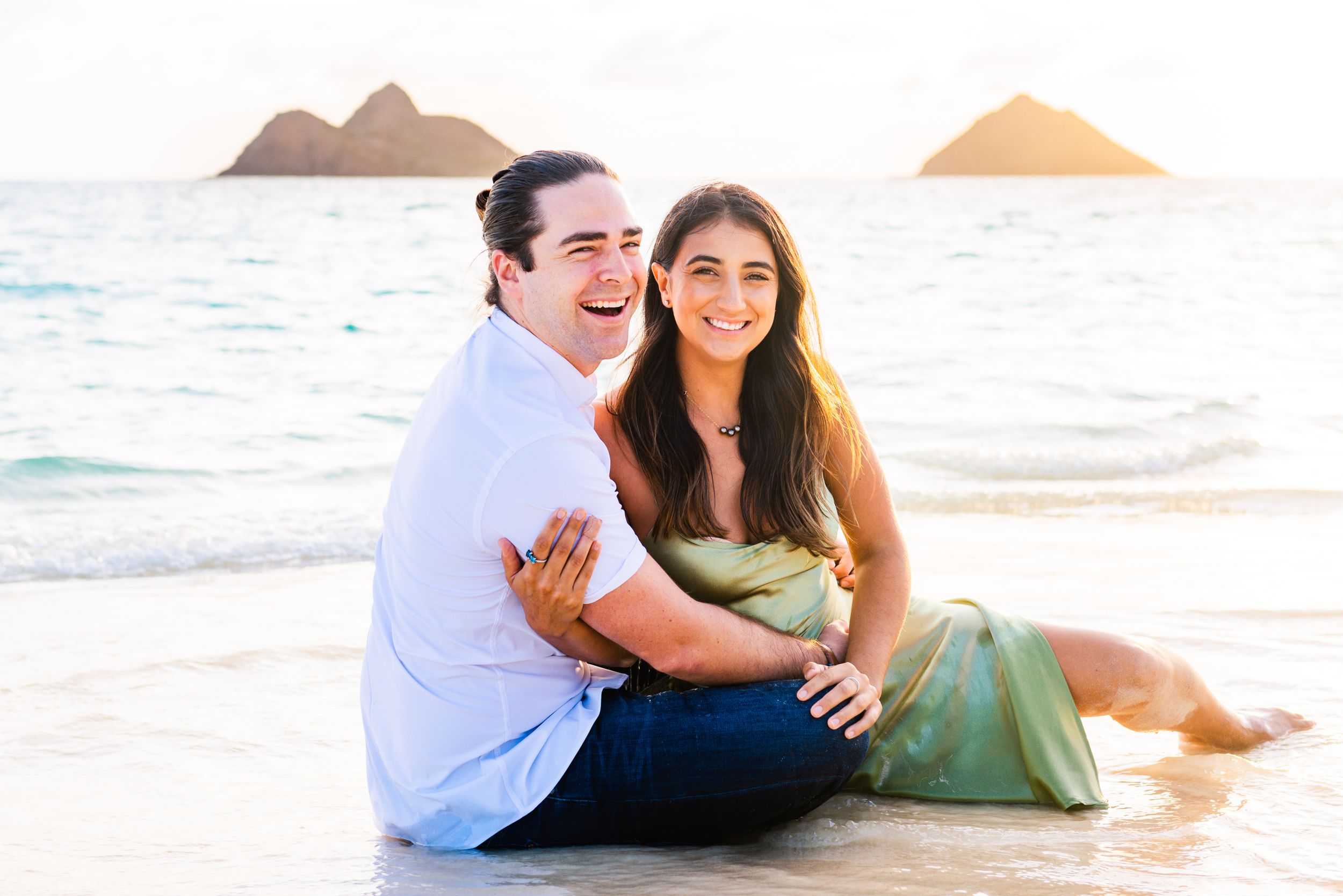 Couple laughing during golden hour photos in Oahu.