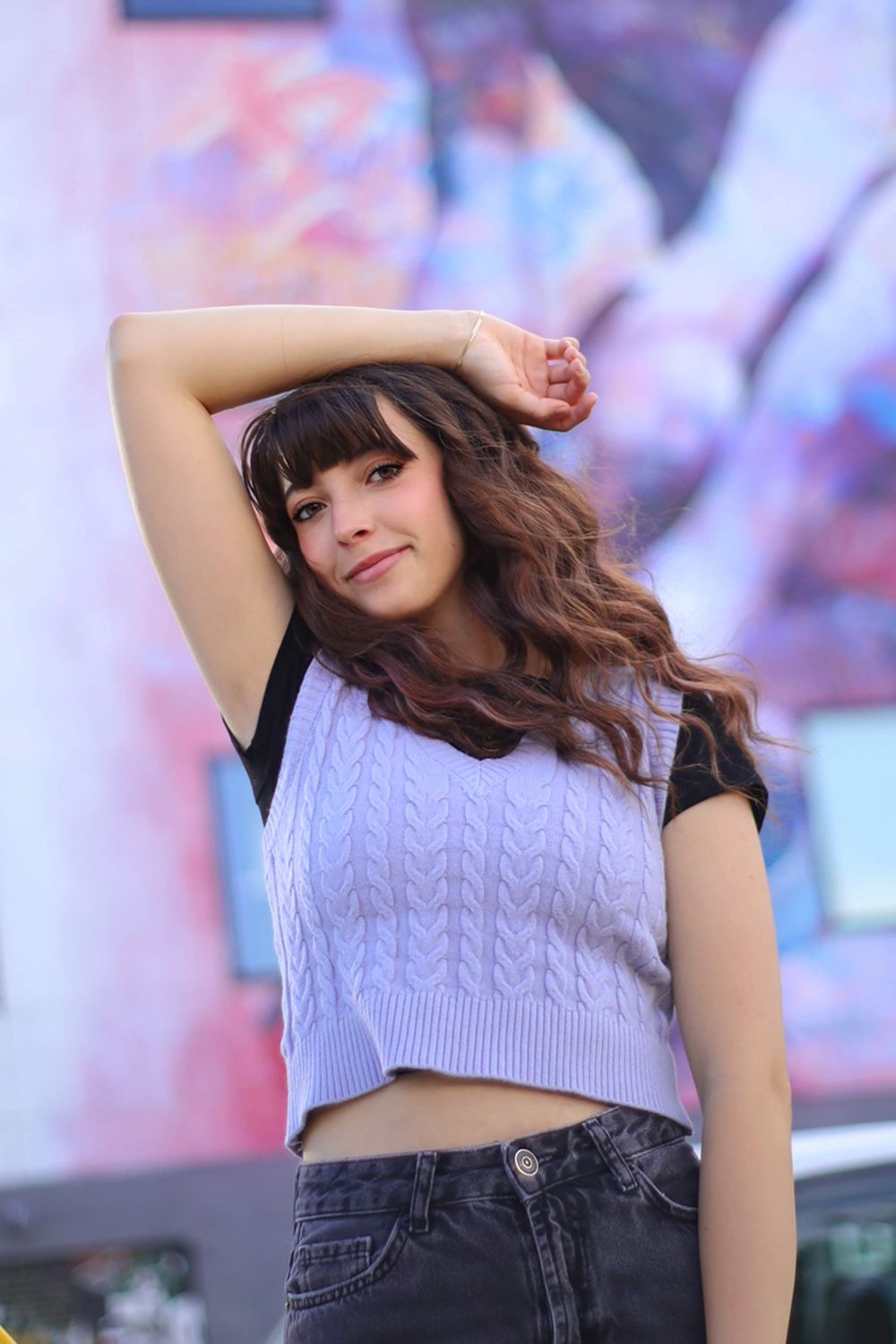 Casual lifestyle portrait featuring lavender knit top against pastel backdrop.