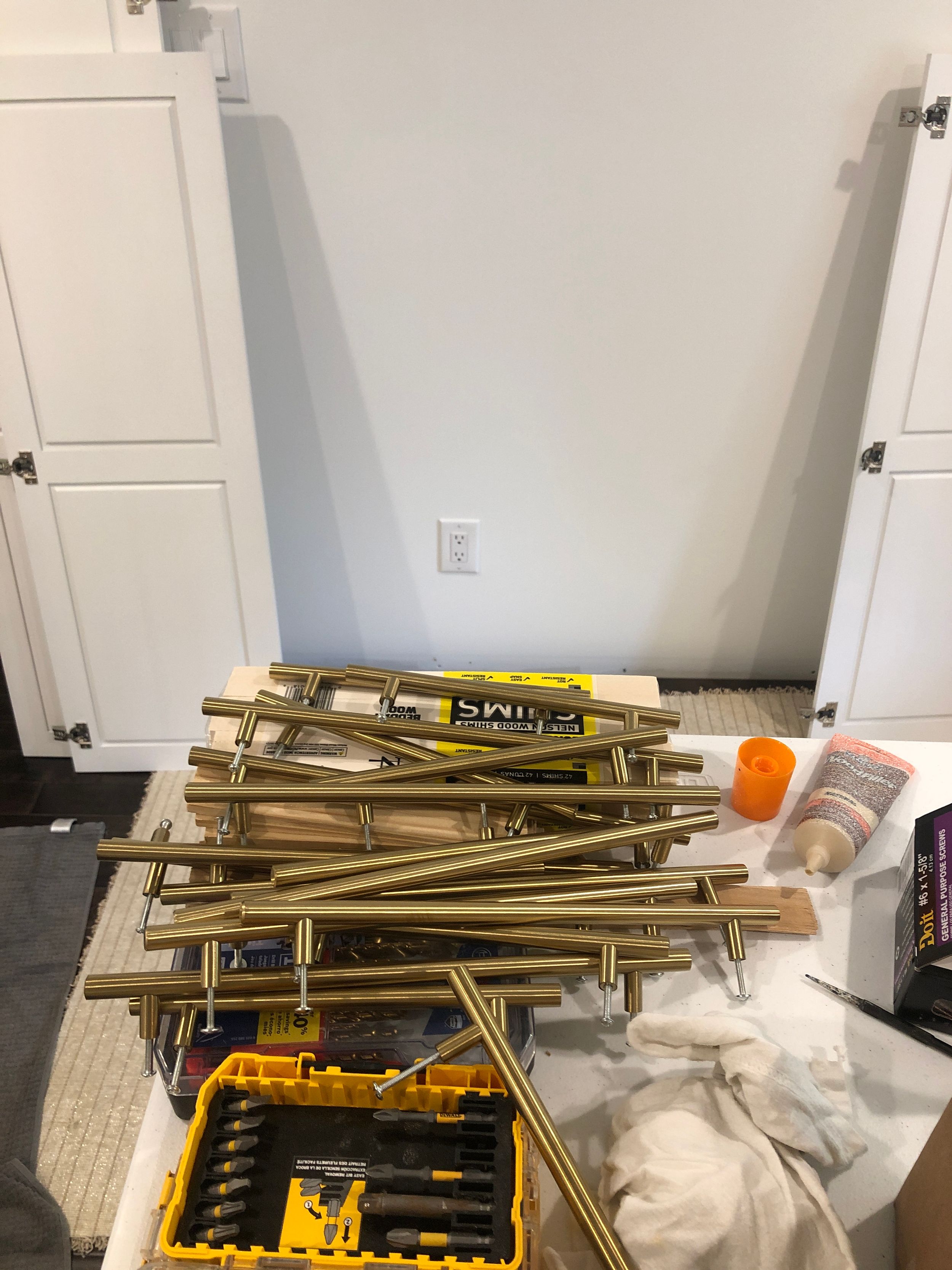 Collection of construction materials and tools piled against a white wall during renovation.