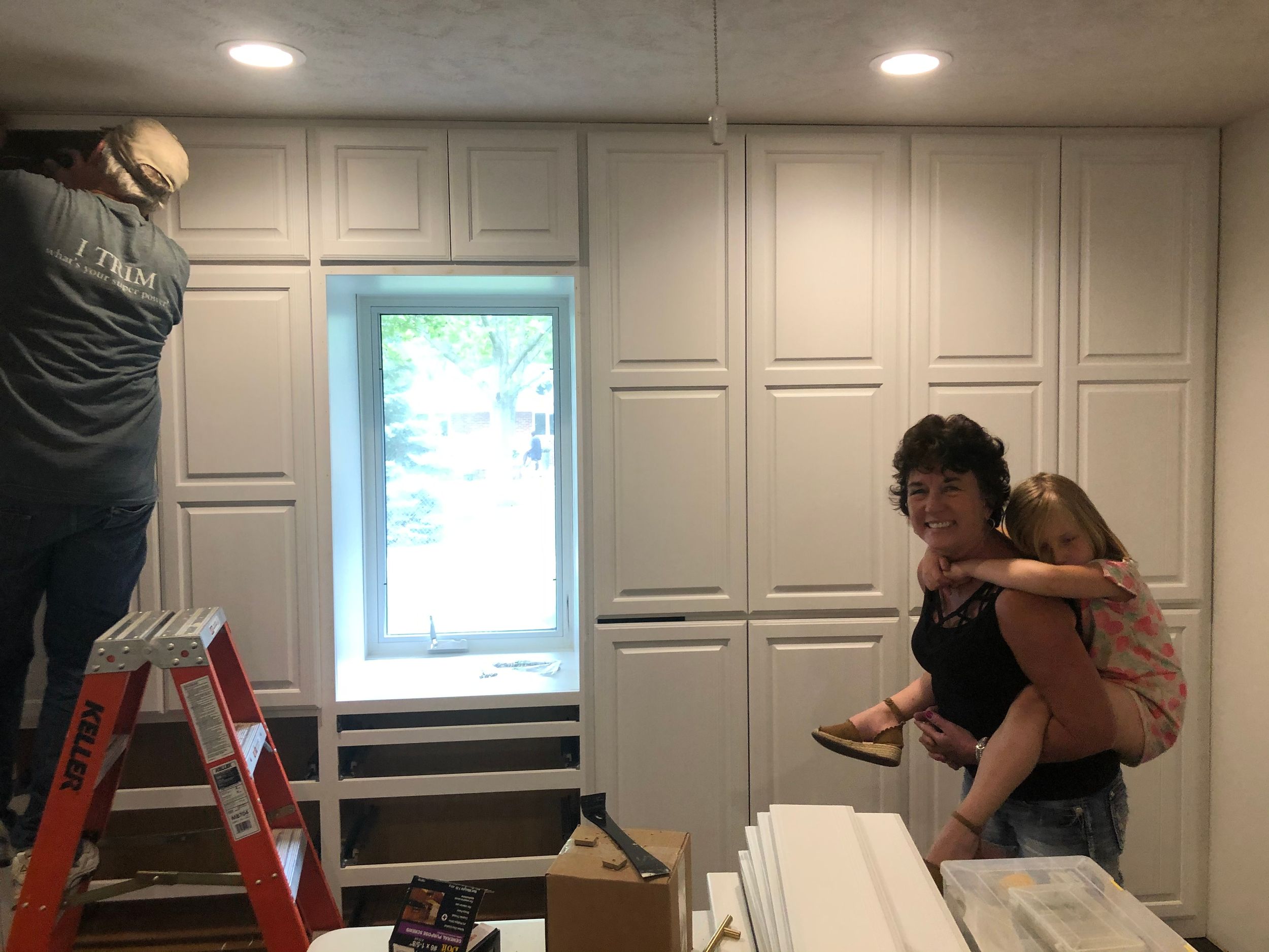 Interior room with white paneled walls and window during construction process.