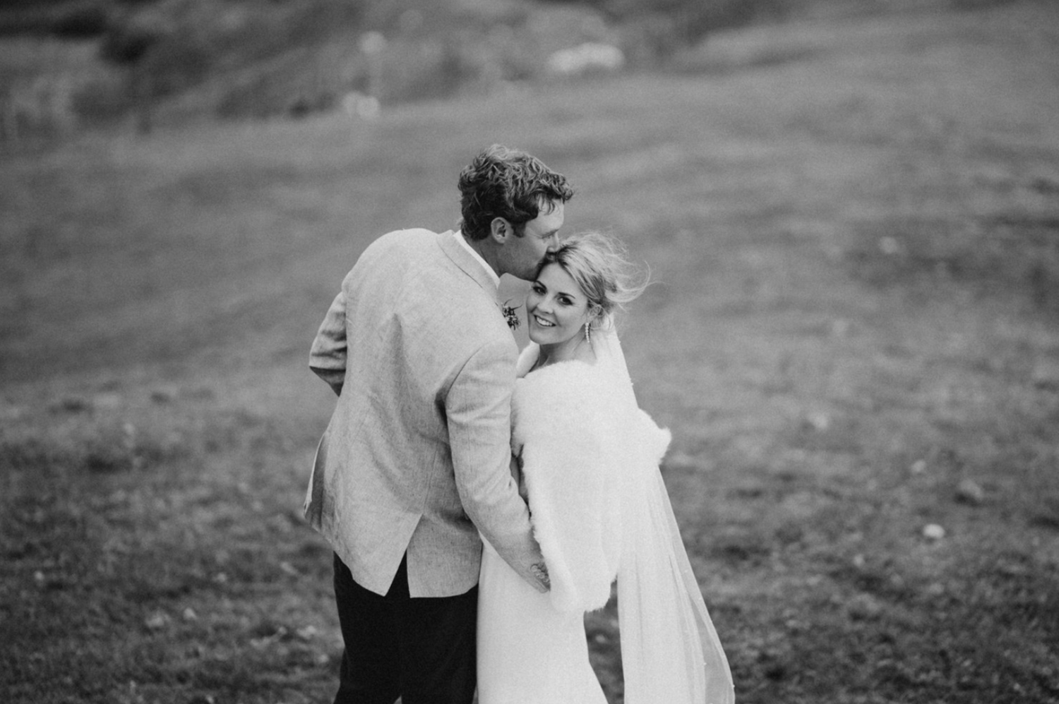 black and white portrait of a bride and groom in a field