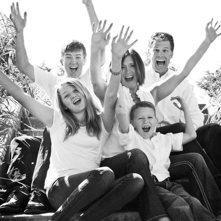 Energetic group photo with people jumping and celebrating outdoors.