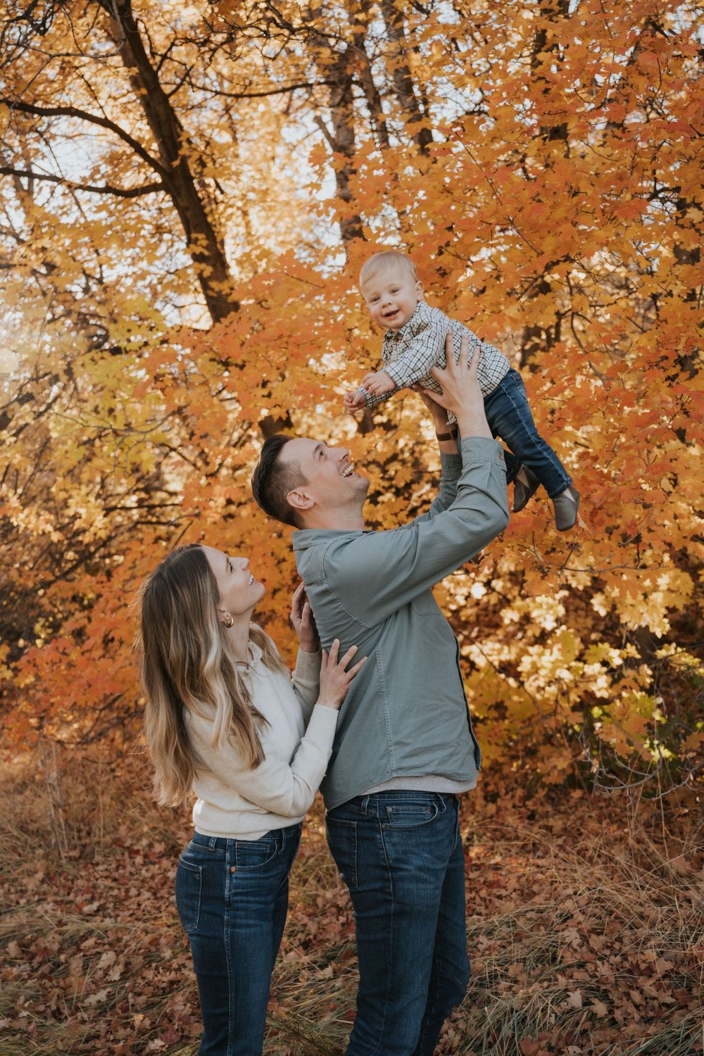 A family enjoys their fall family photoshoot with their new baby, photographed by a talented Utah family photographer