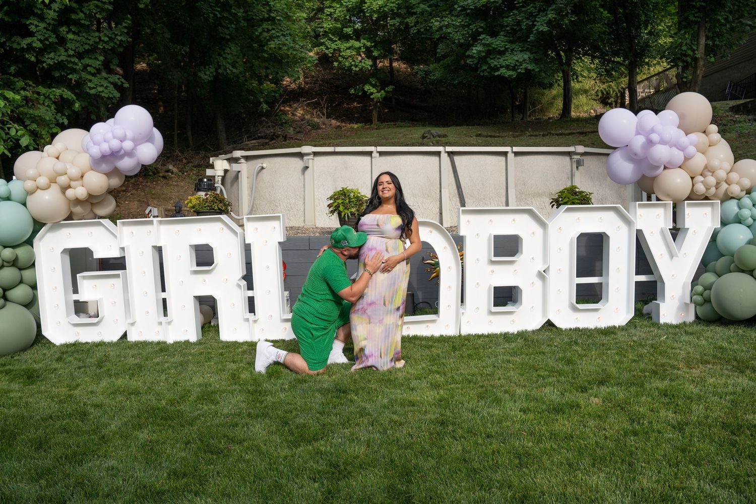 Large white letter decorations spell out words at an outdoor gender reveal party setup.