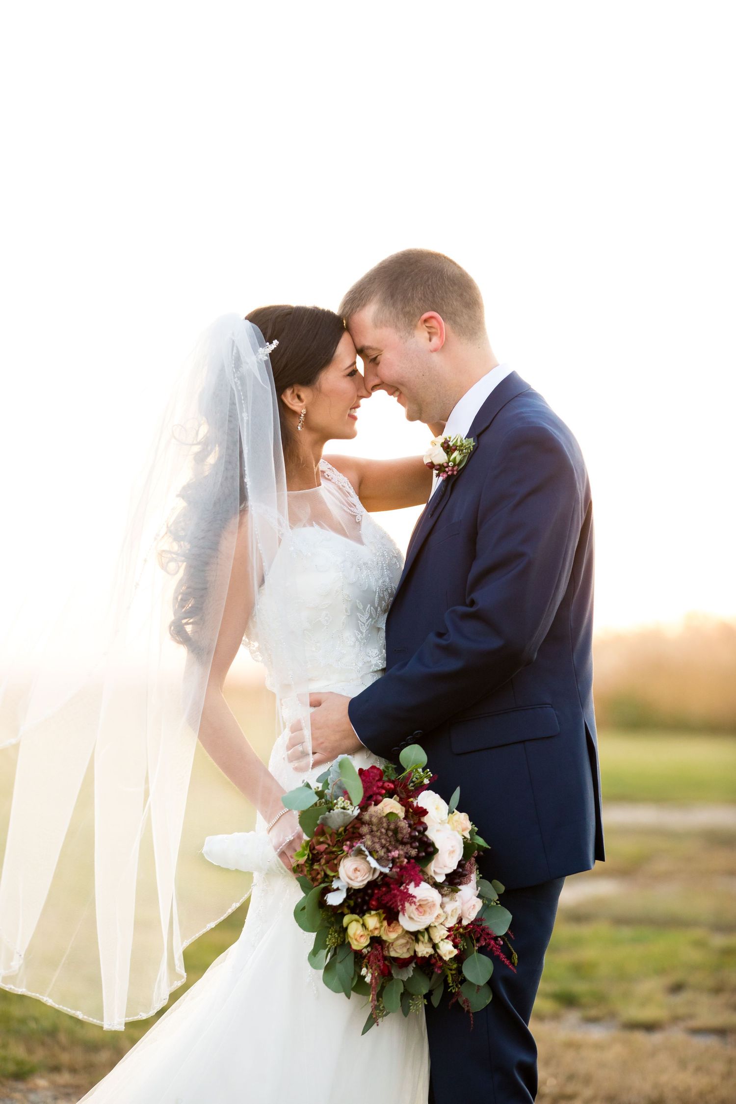 A romantic wedding moment with elegant flowers and formal attire at sunset.
