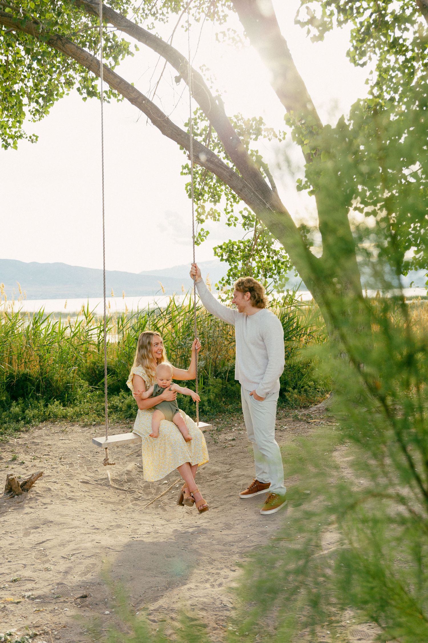 family on a tree swing during sunset at utah lake