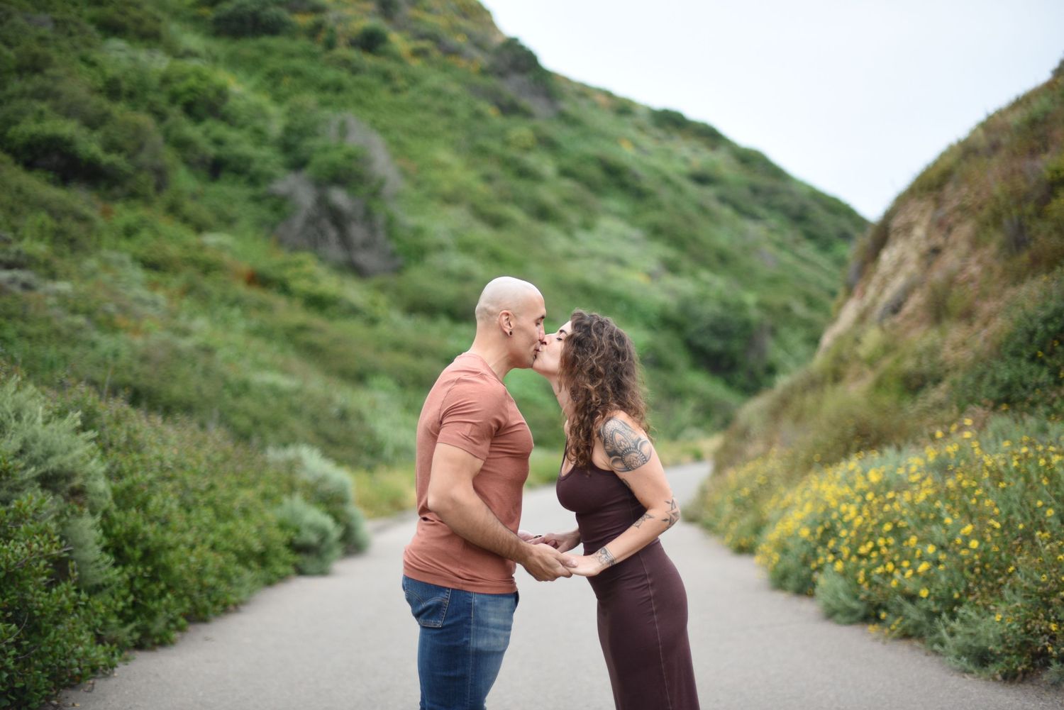 A special moment captured between two people on a scenic coastal trail.