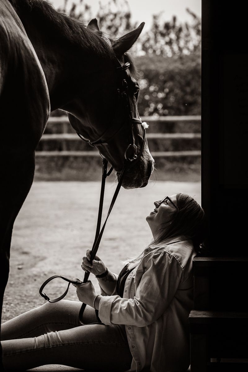 A dramatic black and white portrait showing the connection between horse and companion.