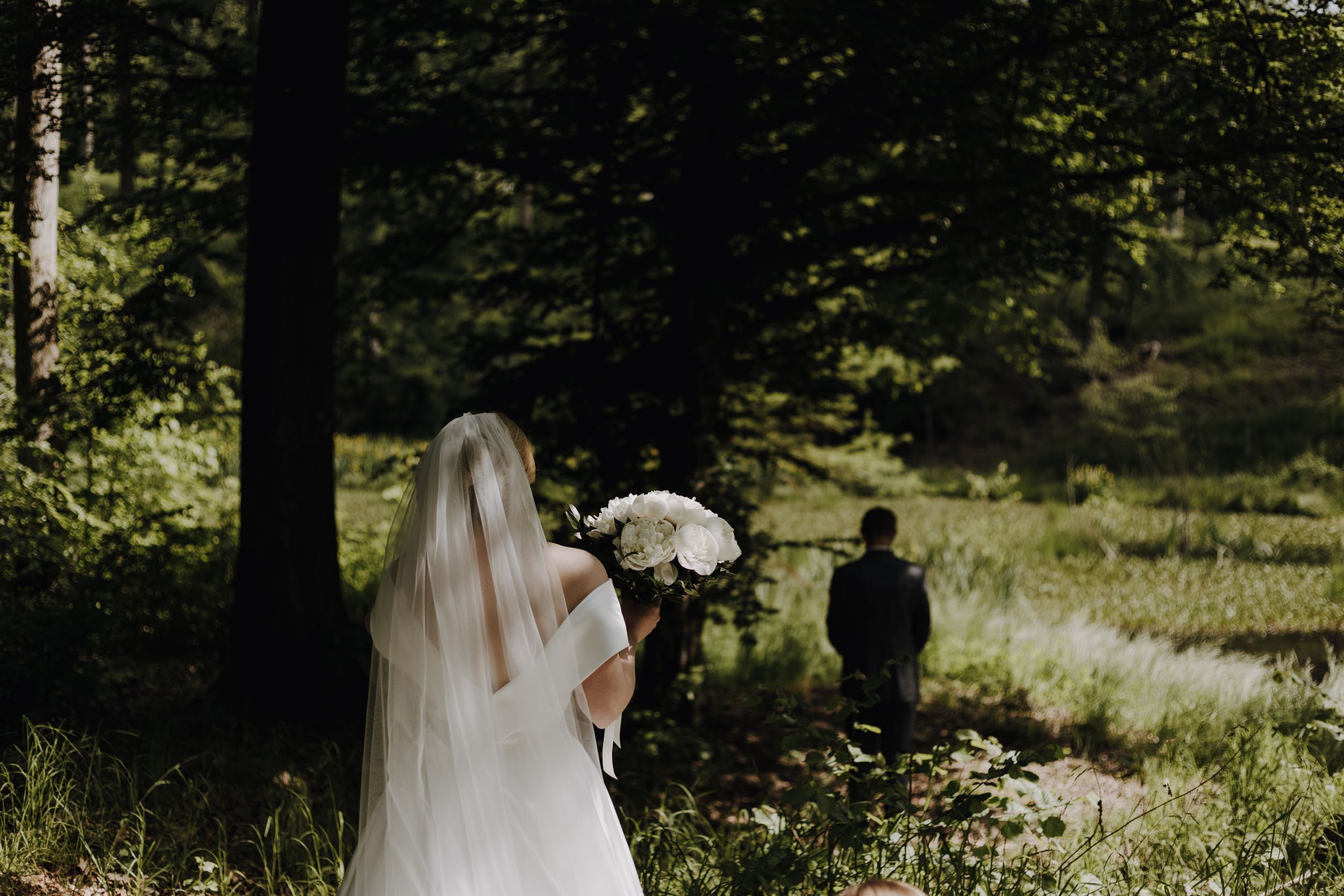 Wedding photography session in a sunlit forest clearing.