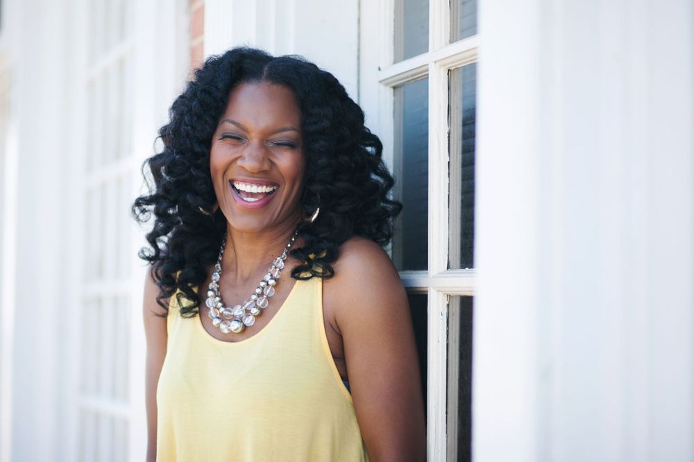 Branding image of an African American woman with a yellow shirt and happy expression