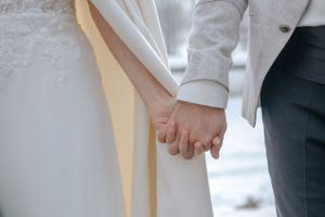 Hochzeitsfotografie: Detailaufnahme der Hände eines Brautpaares bei winterlicher Stimmung, fotografiert nahe Hohenkammer.