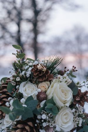 Hochzeitsfotografie: Detailaufnahme eines winterlichen Brautstraußes mit Blumen und Grün, aufgenommen im Raum Dachau.