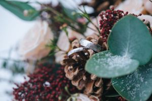 Hochzeitsfotografie: Detailaufnahme eines winterlichen Brautstraußes mit Eukalyptus und Zapfen.