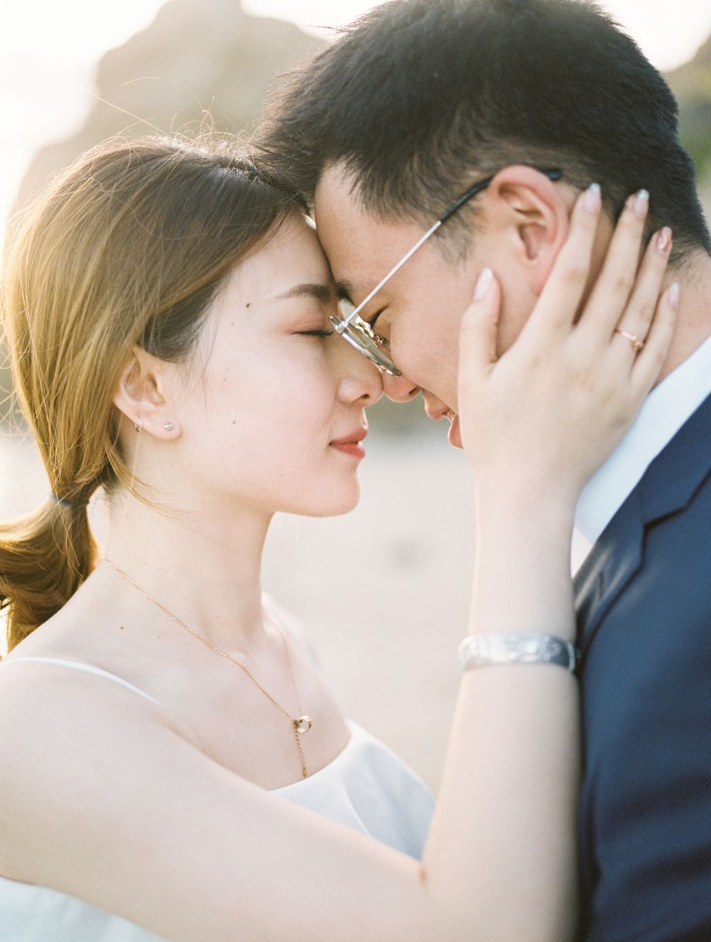 Intimate couple portrait with gentle sunlight and delicate expressions.