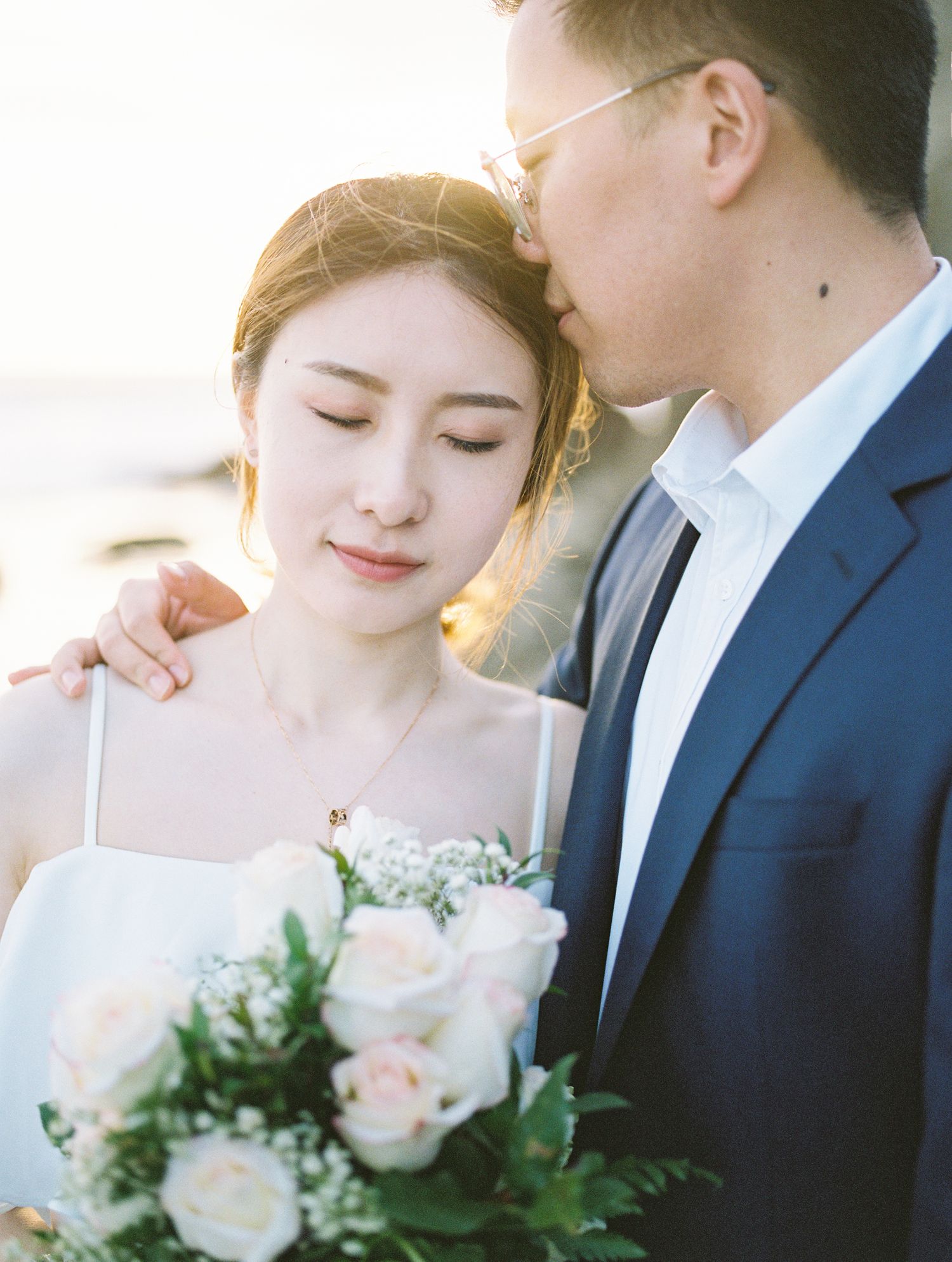 Romantic wedding portrait with soft lighting and pastel roses.