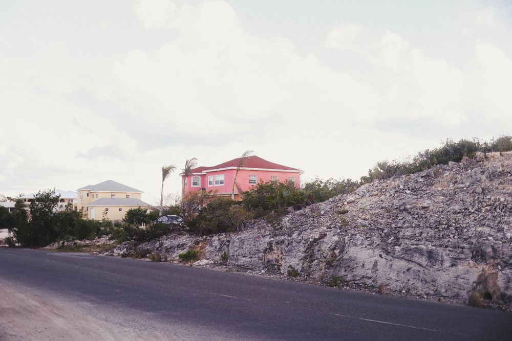 Panoramic view of a coastal road with white buildings and rocky terrain.