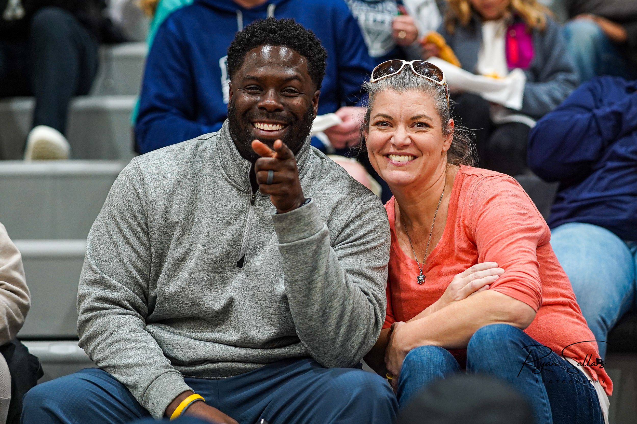 A couple shares a joyful moment while sitting together at a sporting event.