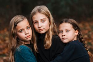 Three sisters are hugging and posing for the camera in Salida, Colorado.