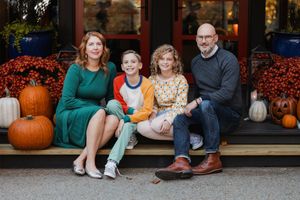 Posed picture of mother, father, and two children in front of their house.