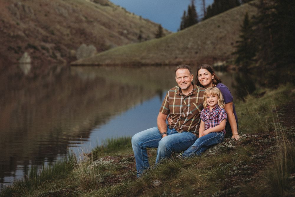 Posed photograph of a family sitting by a lake in San Juan Mountains of Southern Colorado.