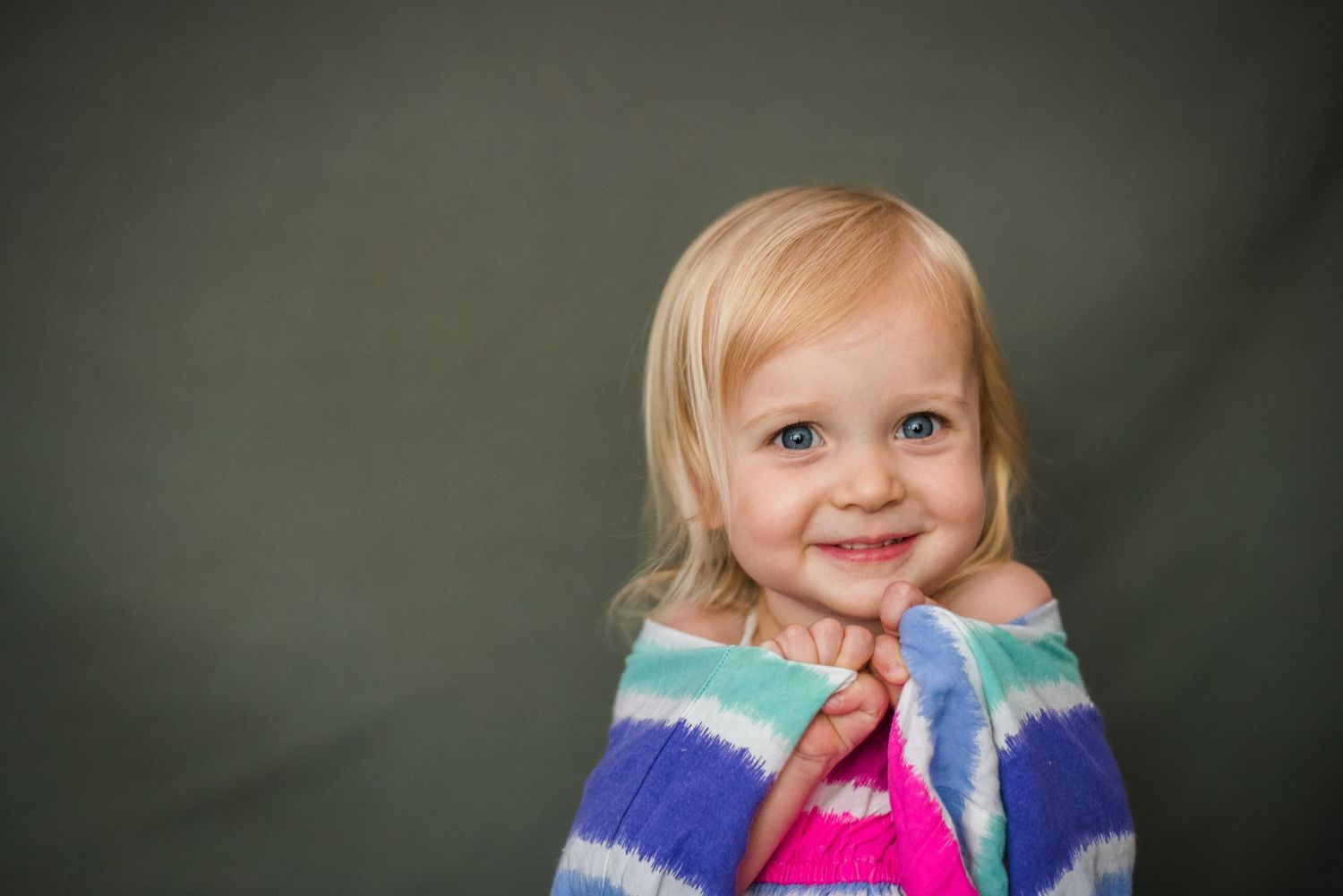 little blonde girl smiles and holds her dress