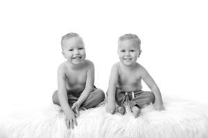 Black and white portrait series showing playful moments on white background.