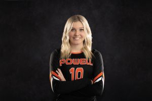 Athletic portrait against dark background wearing orange and black Powell jersey number 10.