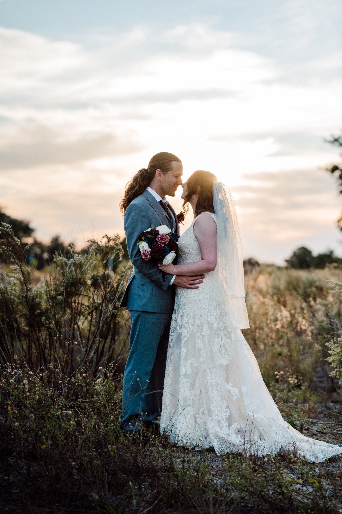 Bride and Groom hug with sunset.