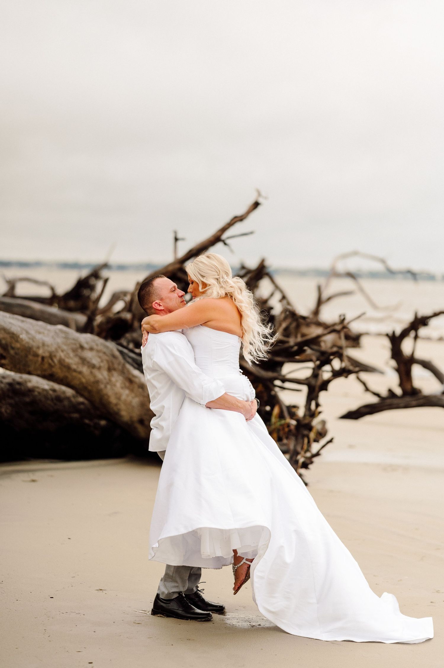 Bride and Groom kissing on beach.