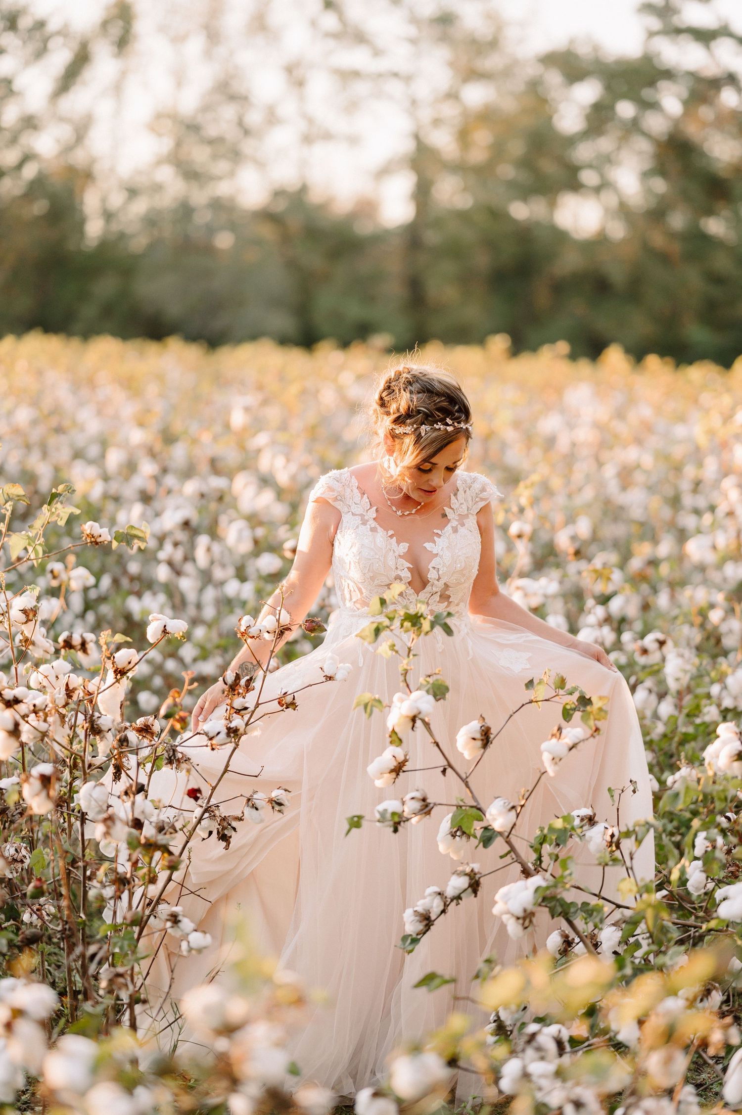 Bride plays with dress in cottonfield.