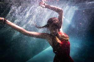 A woman in a red dress underwater