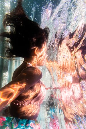 A reflection of a woman's face underwater