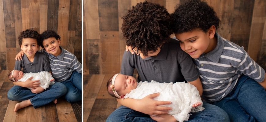 Siblings bonding with newborn during professional studio photography session.