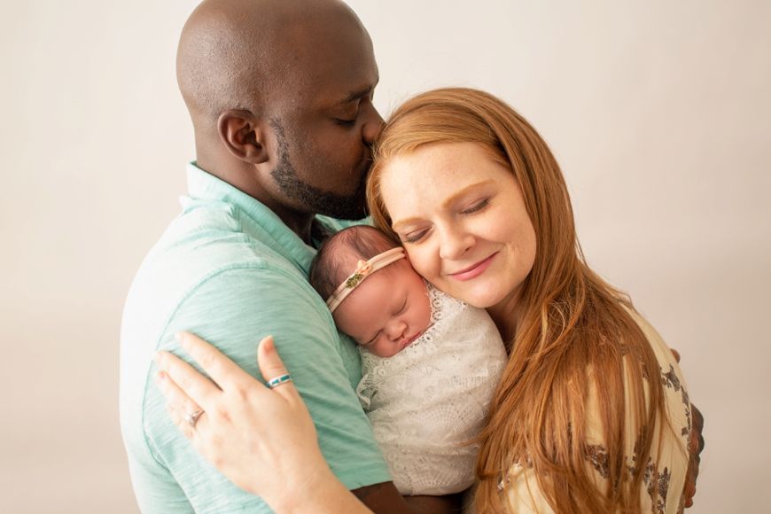 Tender family moment as parents cuddle with their newborn baby.