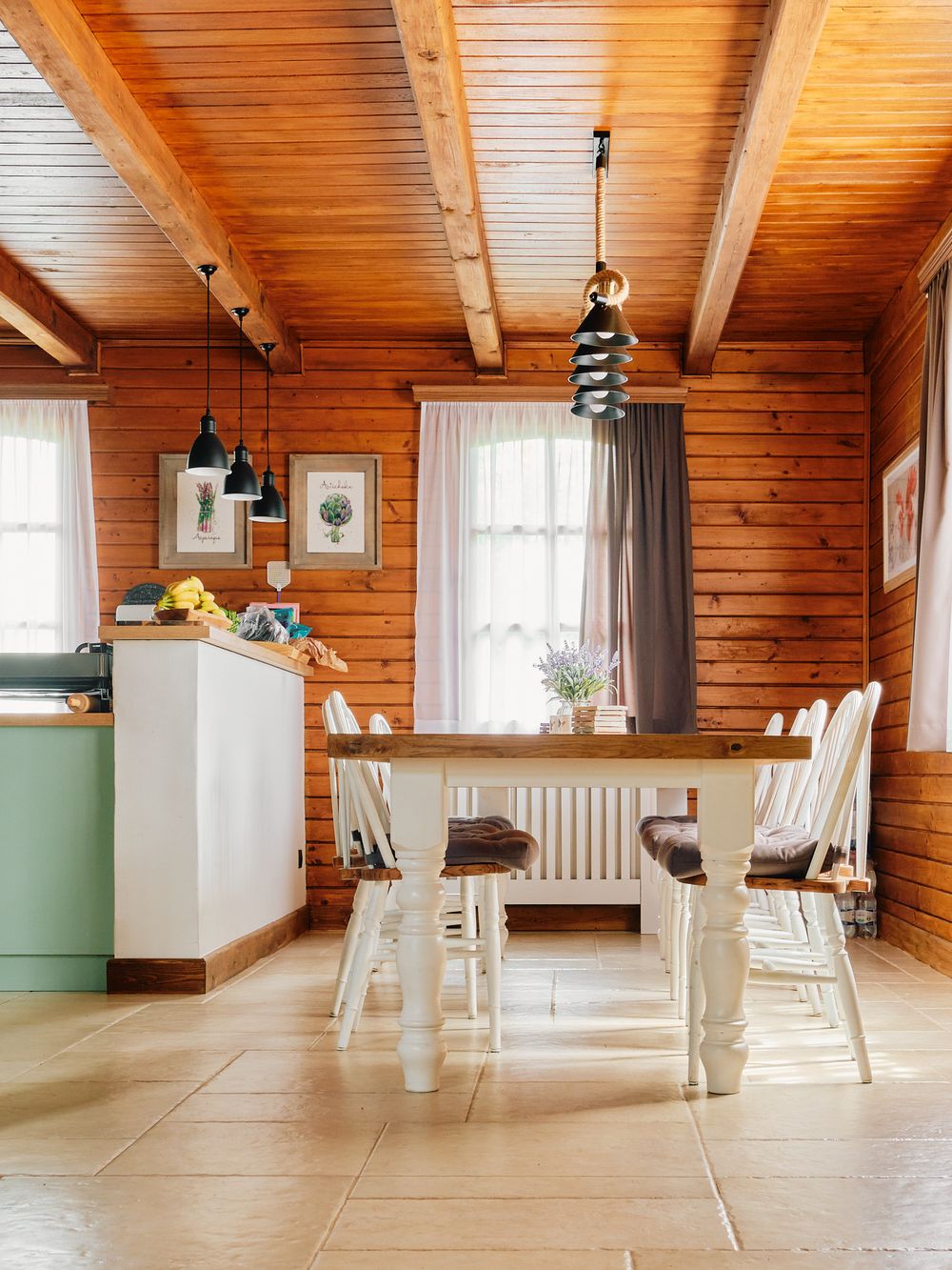 Rustic dining room with wooden ceiling, white furniture, and mint green accent wall.