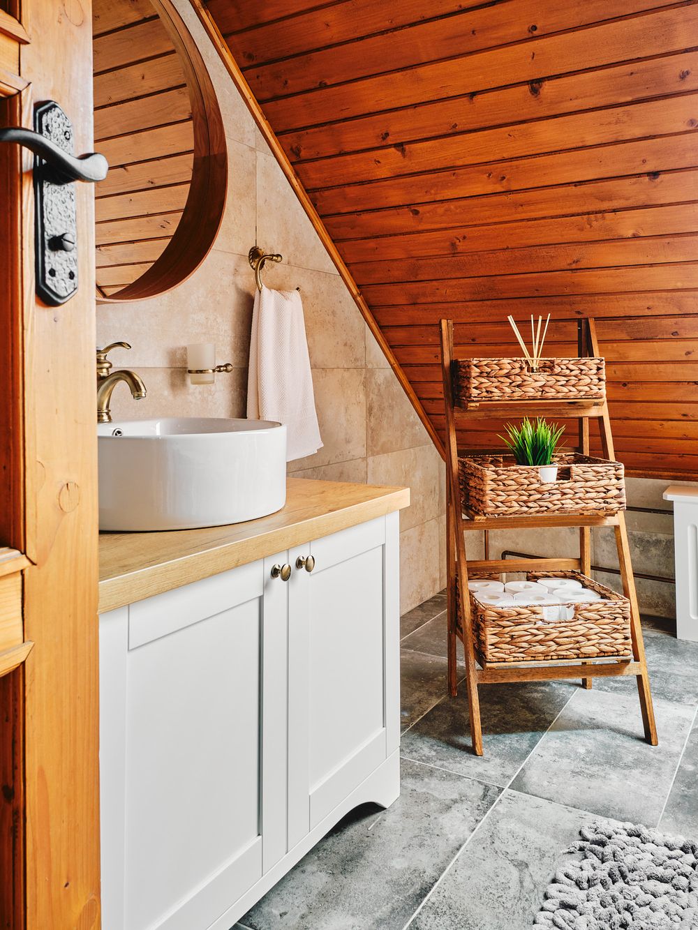 Stylish bathroom vanity with white vessel sink and decorative woven storage baskets.