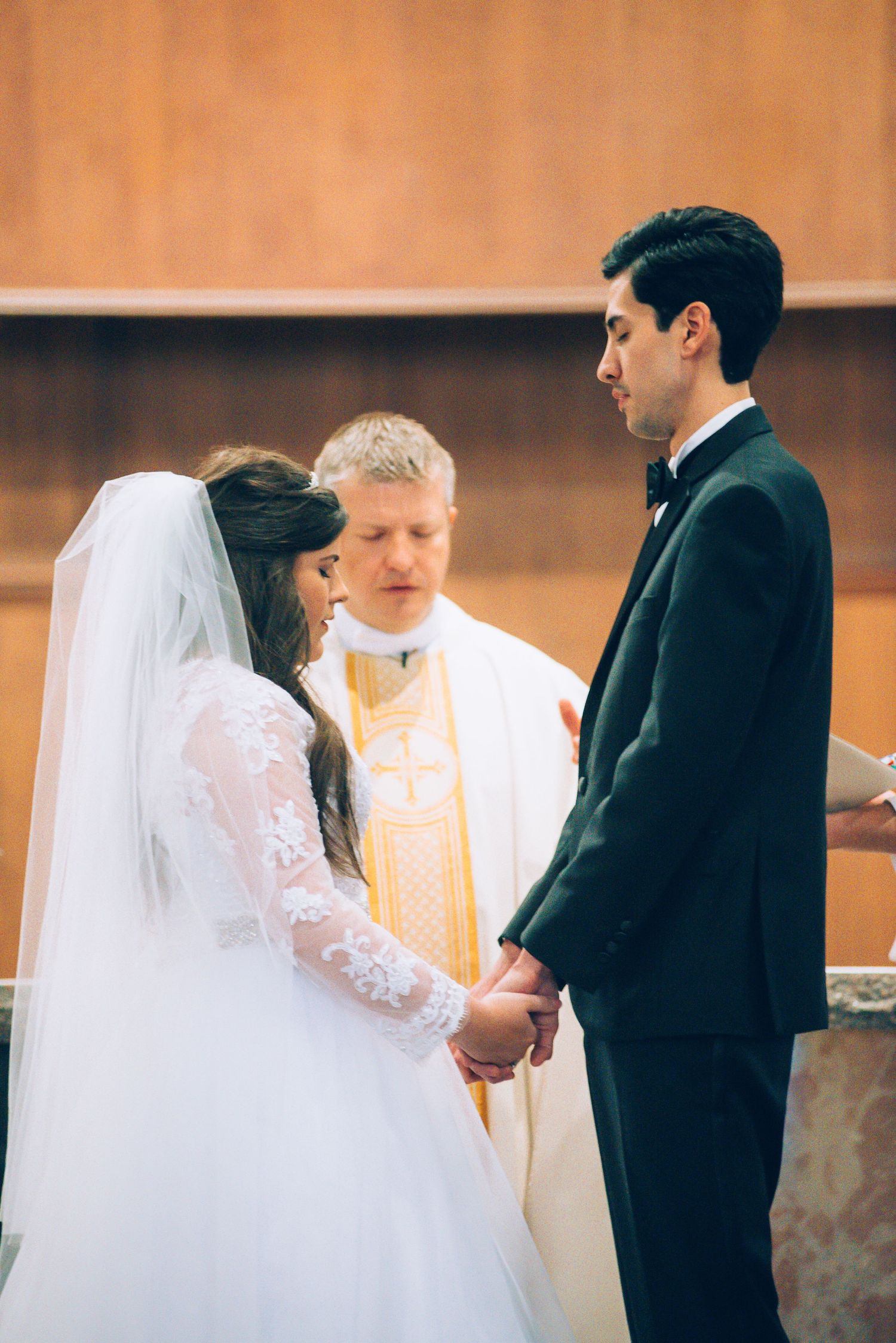 A traditional church wedding ceremony with a priest officiating the service.