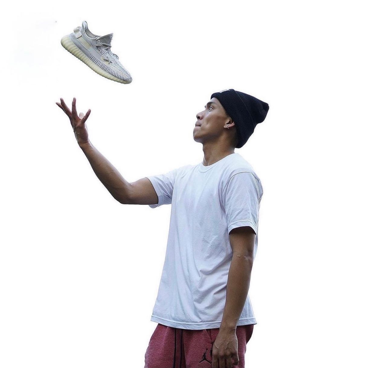 Client in white t-shirt and cap performing a sequence of catching motions outdoors.