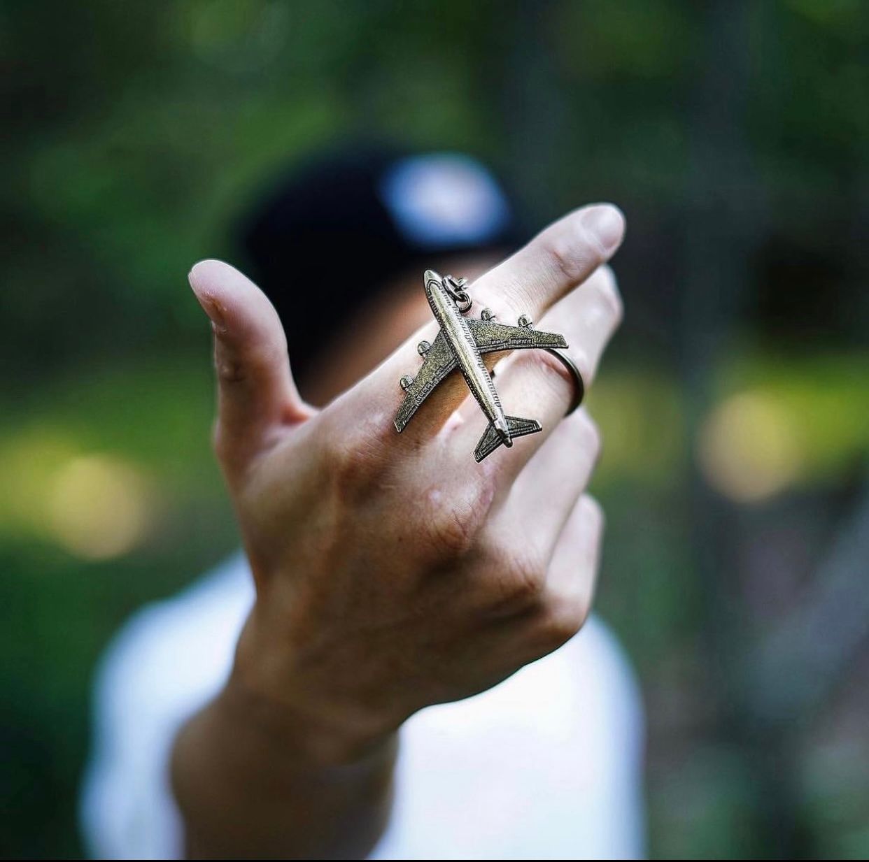 Close-up series of hands with rings making various gestures against a blurred green background.
